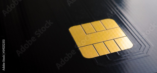 Selective focus on the electronic chip of a credit or debit card. Golden chip on a black electronic board. The concept of the global semiconductor crisis. Semiconductor technologies for dual use.