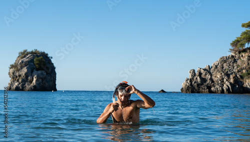 Young man taking of his snorkeling mask after diving. Active vacation, diving, travel concept