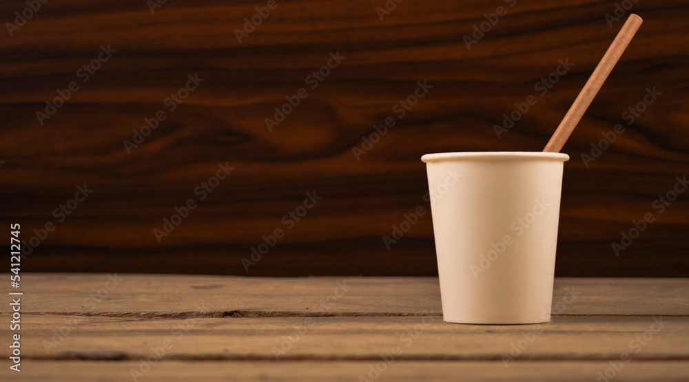 Paper Straw in a Paper Cup on Wooden Table - obrazy, fototapety, plakaty 
