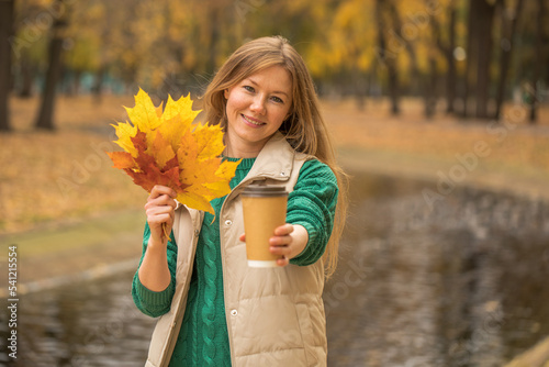 Happy beautiful red-haired woman posing in autumn park