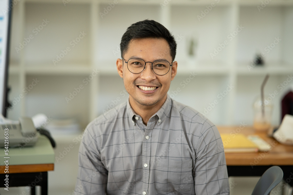 Obraz premium Asian man looking at camera smiling happily