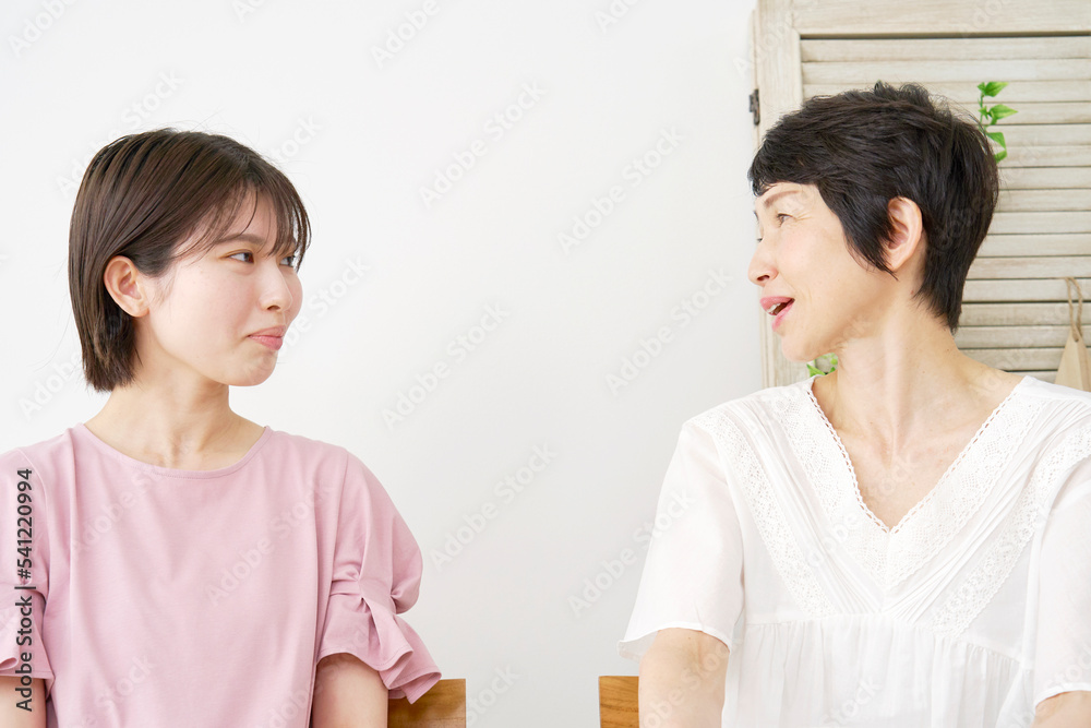自宅で会話する娘と母親