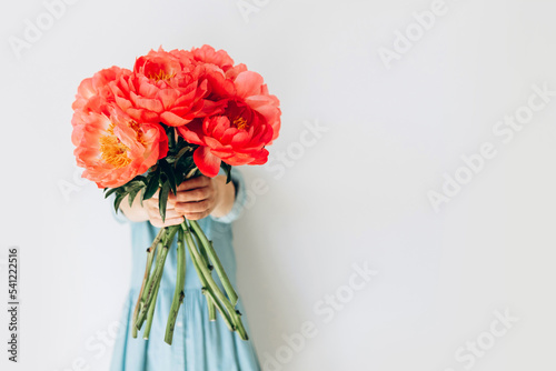 Wallpaper Mural Photo of hipster dreamy girl embracing a huge bouquet of peonies closed isolated turquoise color background Torontodigital.ca