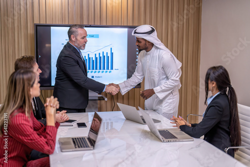 Group of business diversity people and middle east co-worker working in office in the meeting room one employee stand near big screen TV presentation explain the business plan to team