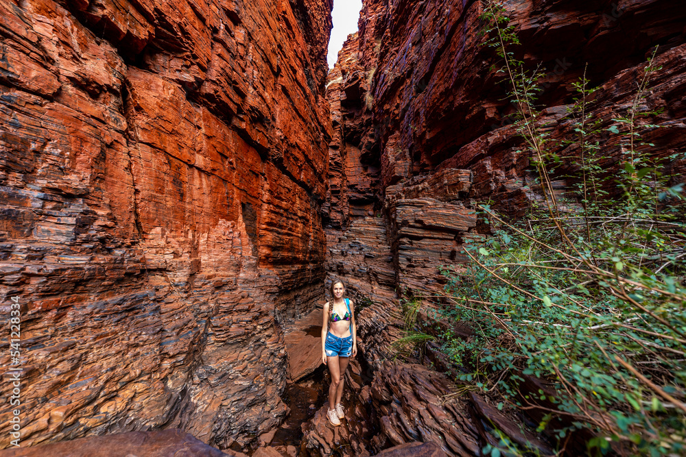backpacker girl hiking in a very narrow canyon in karijini national ...