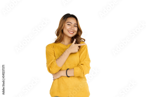Attractive positive young asian brunette woman in yellow sweater on white background. hands pointing