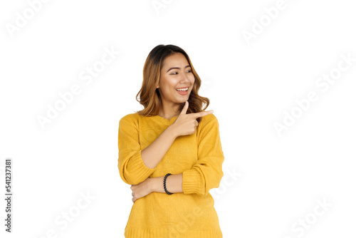 Attractive positive young asian brunette woman in yellow sweater on white background. hands pointing