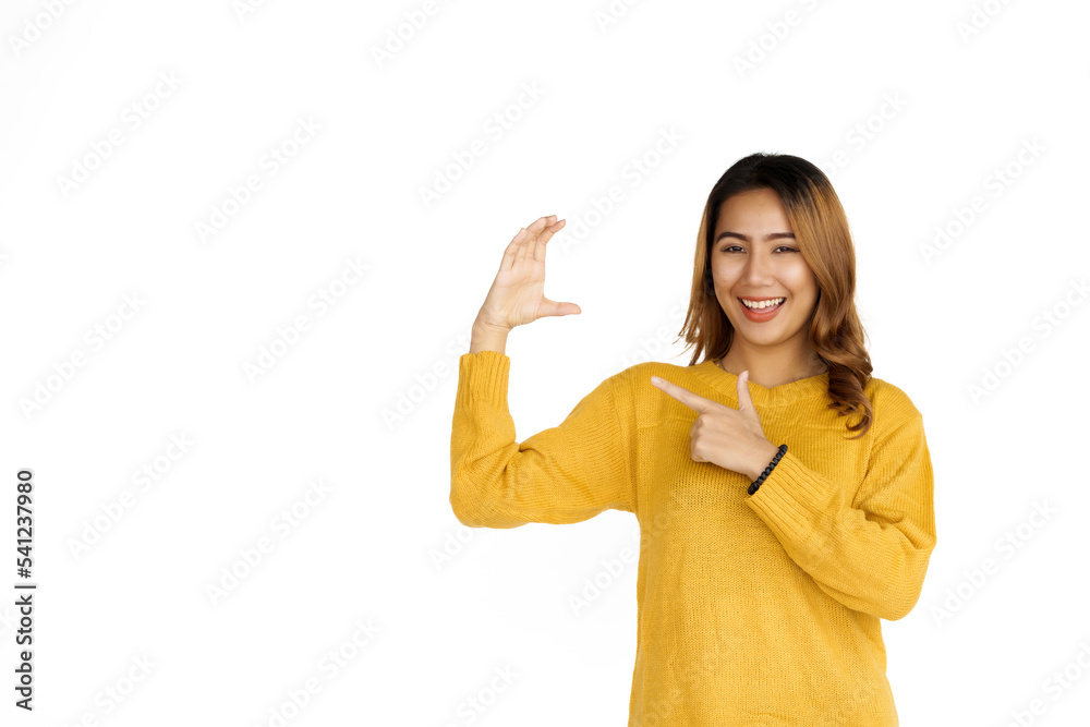 Attractive positive young asian brunette woman in yellow sweater on white background, hands holding something Attractive positive young asian brunette woman in yellow sweater on white background, hands holding something