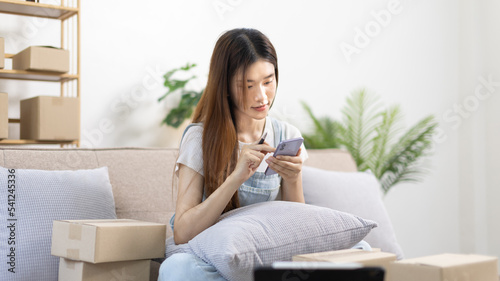 Woman uses mobile phone or tablet to chat with customers who come to order product, Freelance work at home, Conversation with customers through massage, Small business owner, SME entrepreneur.