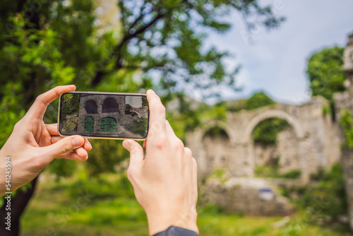 Obraz na płótnie Augmented reality concept. Hand holding smart phone use AR application to check relevant information about building that was here in ancient times. Augmented reality in history and architecture w salonie