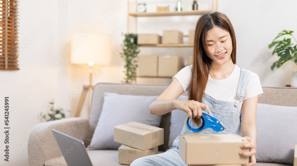 Woman is packing in the mailbox to prepare to deliver it to the customer, Working at home and owning businesses, Online shopping SME entrepreneur, Packing box, Sell online, Freelance working. Woman is packing in the mailbox to prepare to deliver it to the customer, Working at home and owning businesses, Online shopping SME entrepreneur, Packing box, Sell online, Freelance working.