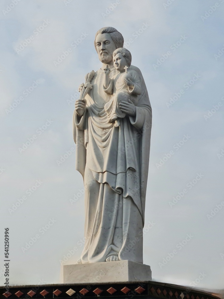 statue of a father of a church holding a baby boy