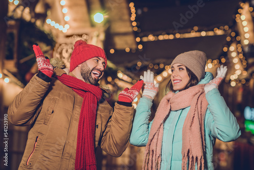Portrait of two positive amazed partners raise arms gloves have fun good mood x-mas spirit time outside