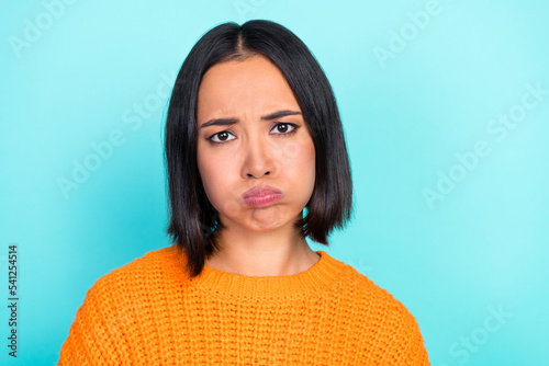 Photo of sad upset lovely childish girl with straight hairdo dressed orange pullover plump lips isolated on teal color background