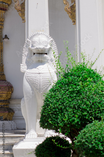Beautiful stucco lion sculpture in front of the door of a Thai temple.