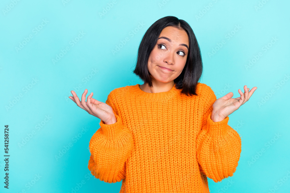 Photo of positive funny nice cute girl with bob hairdo dressed orange pullover look empty space isolated on turquoise color background Photo of positive funny nice cute girl with bob hairdo dressed orange pullover look empty space isolated on turquoise color background