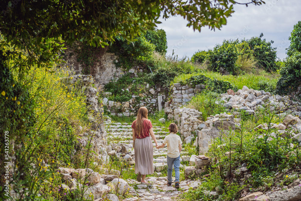 Mom and son tourists walks through the old town of Bar in Montenegro. Happy tourist walks in the mountains. Suburbs of the city of Bar, Montenegro, Balkans. Beautiful nature and landscape