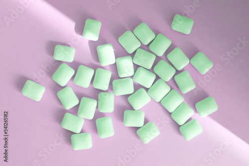 Green chewing gums on a roch background, flat lay top view.