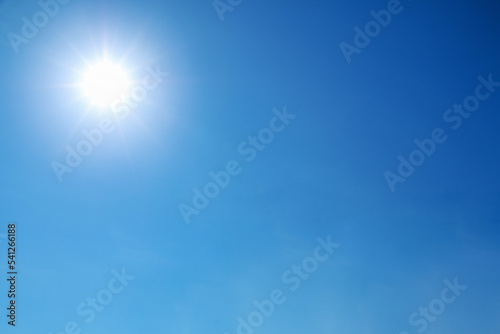 bright sun shines on clear blue sky