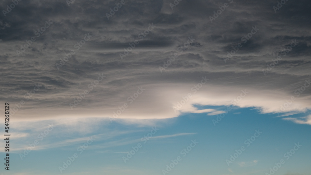 cloudy scary sky, pale white blue sky with scattered cumulus clouds before rain. A gray-blue cloud is moved by a wind current, clouds before rain. cloud background, gray-blue color