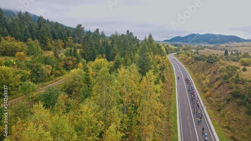 Aerial view a professional cyclist people ride on road next to fields. Beautiful nature. Drone video. Sport. Slow motion