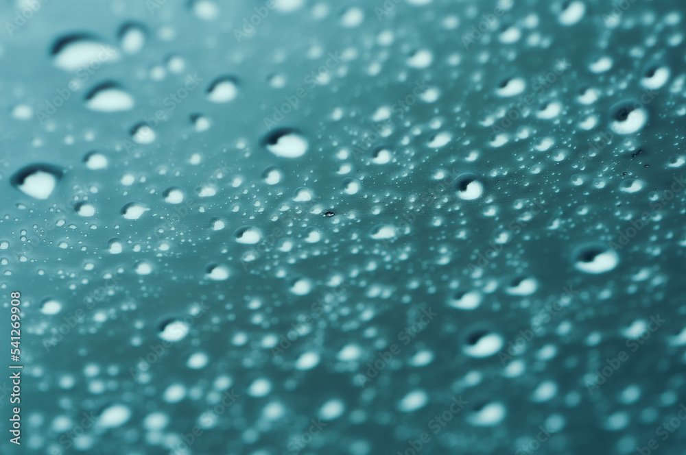 The texture of the drops on the glass. Blue background. Sweaty surface. Car window. The texture of the drops on the glass. Blue background. Sweaty surface. Car window.