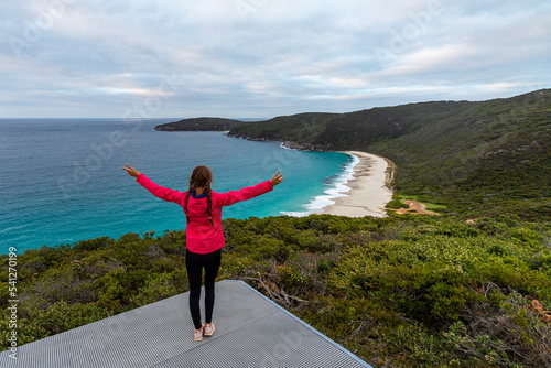 A girl stands on a hill enjoying the panorama of shelly beach in west cape howe national park in western australia; hiking in western australia