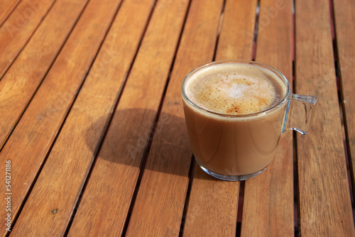 Obraz na płótnie Fresh coffee on a wooden table during breakfast. The sun falls on the cup. Time to relax w salonie