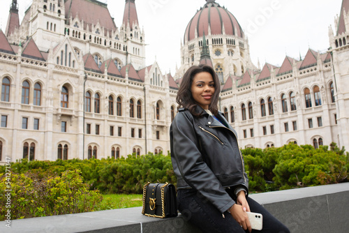 Happy black woman student enjoying great view of the Parliament building in Budapest city, travel in Europe concept.