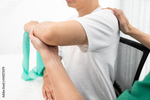 Therapist treating a male injured by shoulder impingement test.
