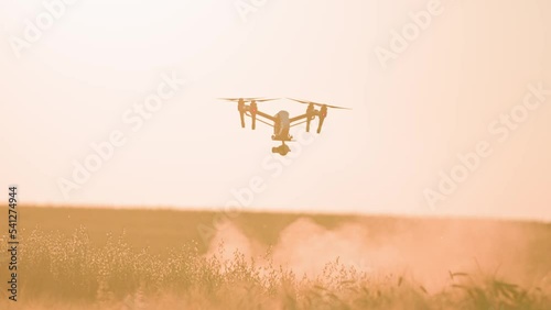 Shot of flying agriculture drone. Sunlight around in sky rural aerial helicopter. Farming field. Harvest. Innovation. New technology. Plant landscape. Slow motion