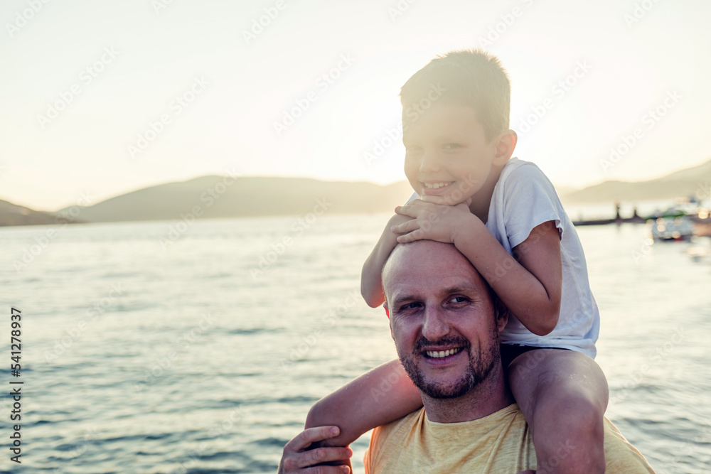 Shot of a joyful father and daugther on the beach. Portrait of a happy father and son spending time together at the beach.