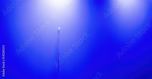 Light on a free music stage with mic, scene with blue spotlights on a background