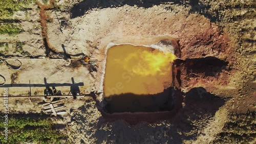 Drone view of pit filled with water. Gas burning. Industrial concept. Gas pipeline network. Gas production. Enterprise. Daytime, job. Summer, outdoor