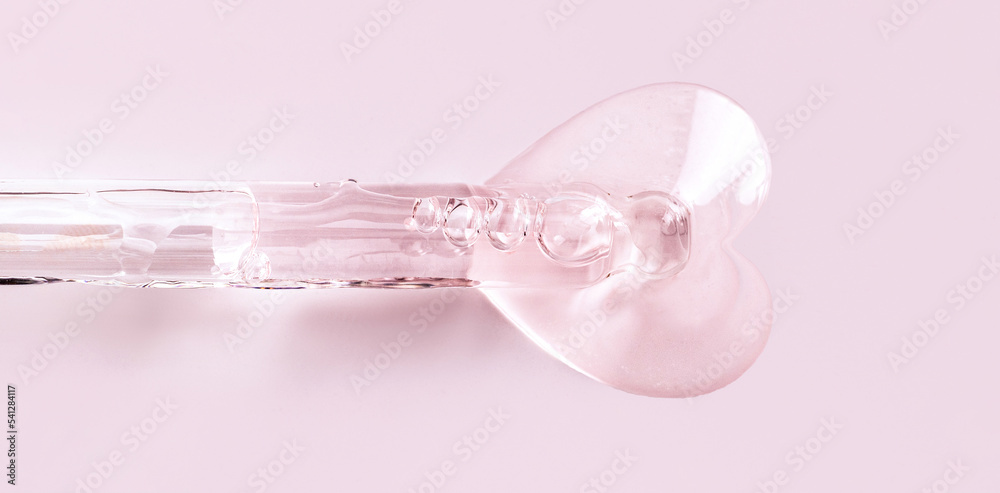 banner pipette with serum drop in the shape of a heart on a pink background banner pipette with serum drop in the shape of a heart on a pink background