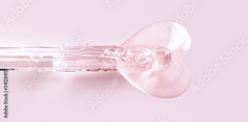 banner pipette with serum drop in the shape of a heart on a pink background