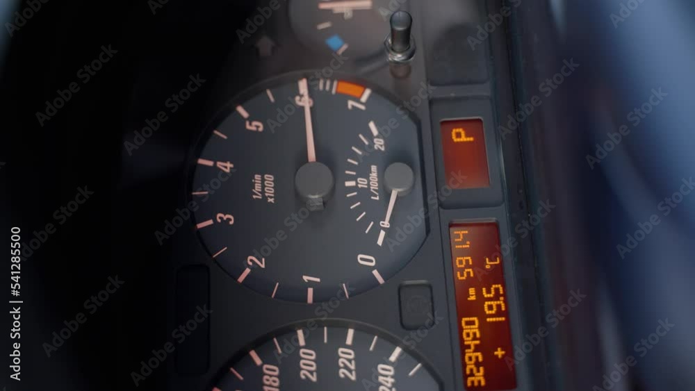 Black dashboard in a car. Tachometer circle. The tachometer needle moves and shows the engine speed. The red mark shows over-revving. Vertical video. Close-up