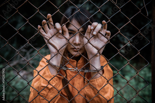 Portrait of women desperate to catch the iron prison,prisoner concept,thailand people,Hope to be free,If the violate the law would be arrested and jailed. © reewungjunerr
