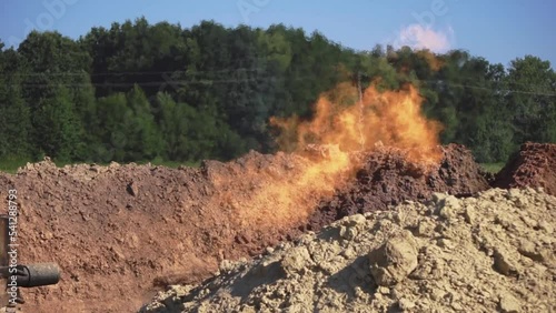 Shot of agricultural field of industrial enterprise. Fire and soil on background of green forest. Daytime, out of town. Production of natural gas. Rural, scenic