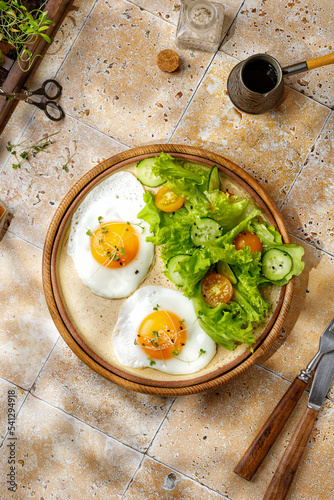 Breakfast concept with coffee and eggs, micro greens and salad. Beige background, tile, top view.