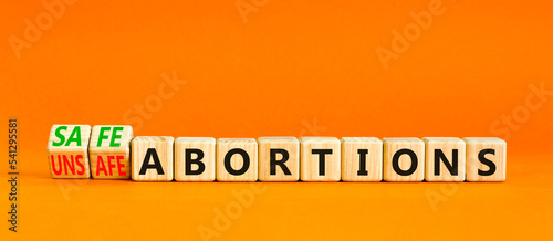 Safe or unsfe abortions symbol. Concept words Safe abortions and Unsfe abortions on wooden cubes. Beautiful orange table orange background. Medical safe or unsfe abortions concept. Copy space. photo