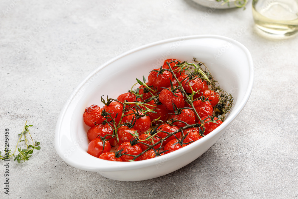 Dish with Baked mini cherry tomatoes with oil, garlic and thyme. Diet dinner idea. Vegetable, vegan. Dish with Baked mini cherry tomatoes with oil, garlic and thyme. Diet dinner idea. Vegetable, vegan.