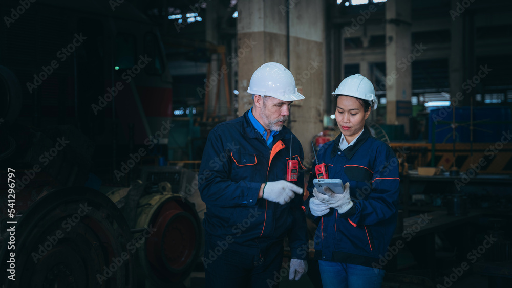 Professional Engineers are on duty, discussing, inspecting, and maintaining the machine in the train garage that is malfunctioning. Professional Engineers are on duty, discussing, inspecting, and maintaining the machine in the train garage that is malfunctioning.