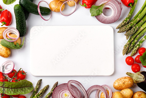 Fresh organic food vegetables frame with white cutting board on white background. Vegetables background. Top view, copy space, place for text. Set, group.