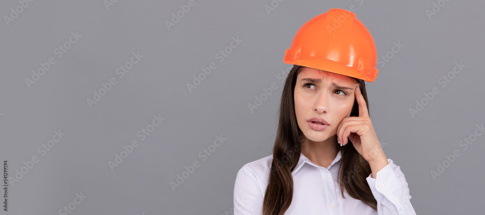 Woman isolated face portrait, banner with mock up copy space. pondering female construction worker. businesswoman in builder hardhat. Woman isolated face portrait, banner with mock up copy space. pondering female construction worker. businesswoman in builder hardhat.