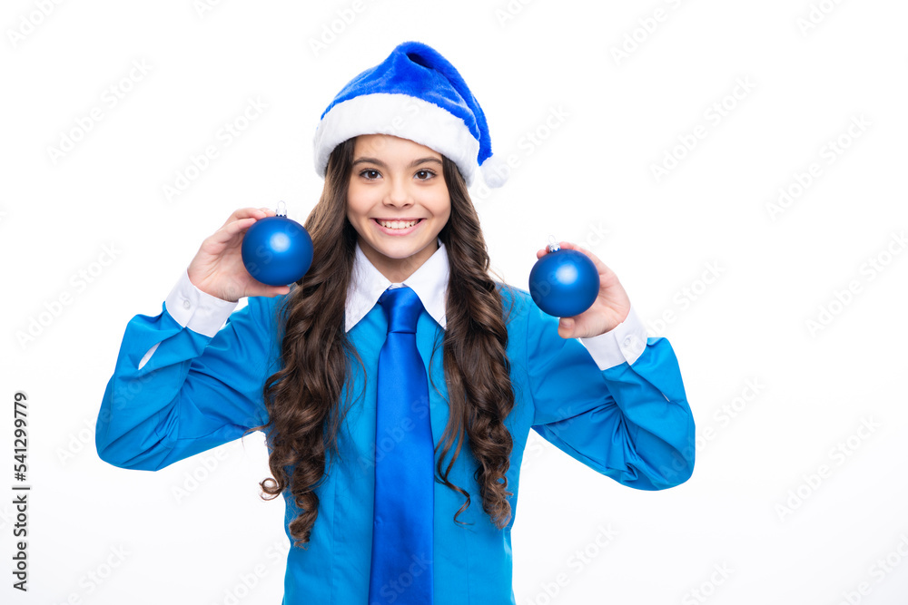 Christmas, New Year kids celebration concept. Portrait a teenage girl child in blue santa hat hold christmas ball, shirt and necktie isolated on white background, copy space. Christmas, New Year kids celebration concept. Portrait a teenage girl child in blue santa hat hold christmas ball, shirt and necktie isolated on white background, copy space.