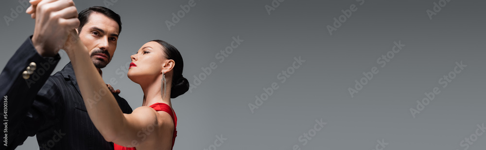 Professional dancers holding hands isolated on grey with copy space, banner Professional dancers holding hands isolated on grey with copy space, banner