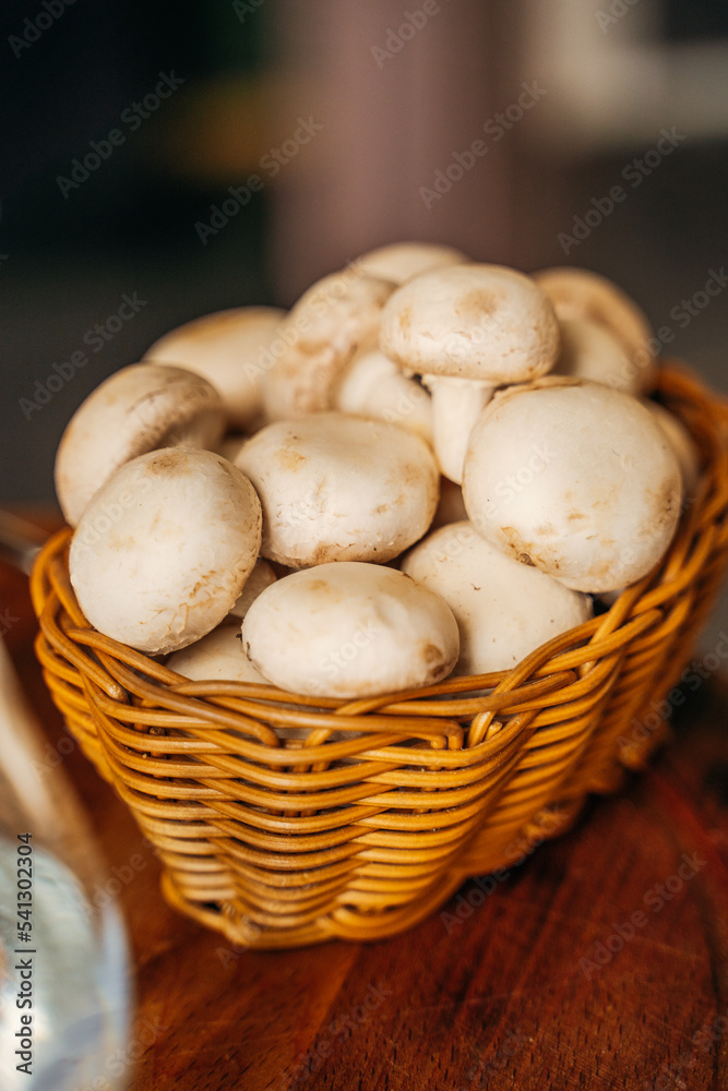 wicker basket with champignon mushrooms on a dark background wicker basket with champignon mushrooms on a dark background
