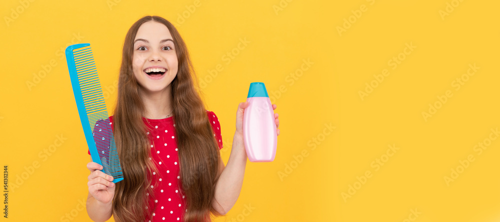surprised child presenting shampoo and hairbrush for long hair on yellow background, beauty. Kid girl hair care, horizontal poster. Banner header with copy space. surprised child presenting shampoo and hairbrush for long hair on yellow background, beauty. Kid girl hair care, horizontal poster. Banner header with copy space.