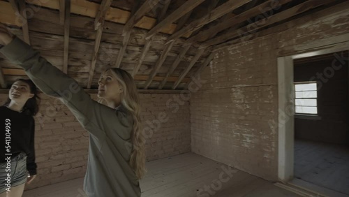 Teenage girls exploring attic in empty house / Grafton, Utah, United States photo